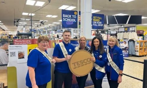 Picture of Tesco staff holding a giant golden coin token for the Golden Grant promotion taken from the Northants Telegraph.